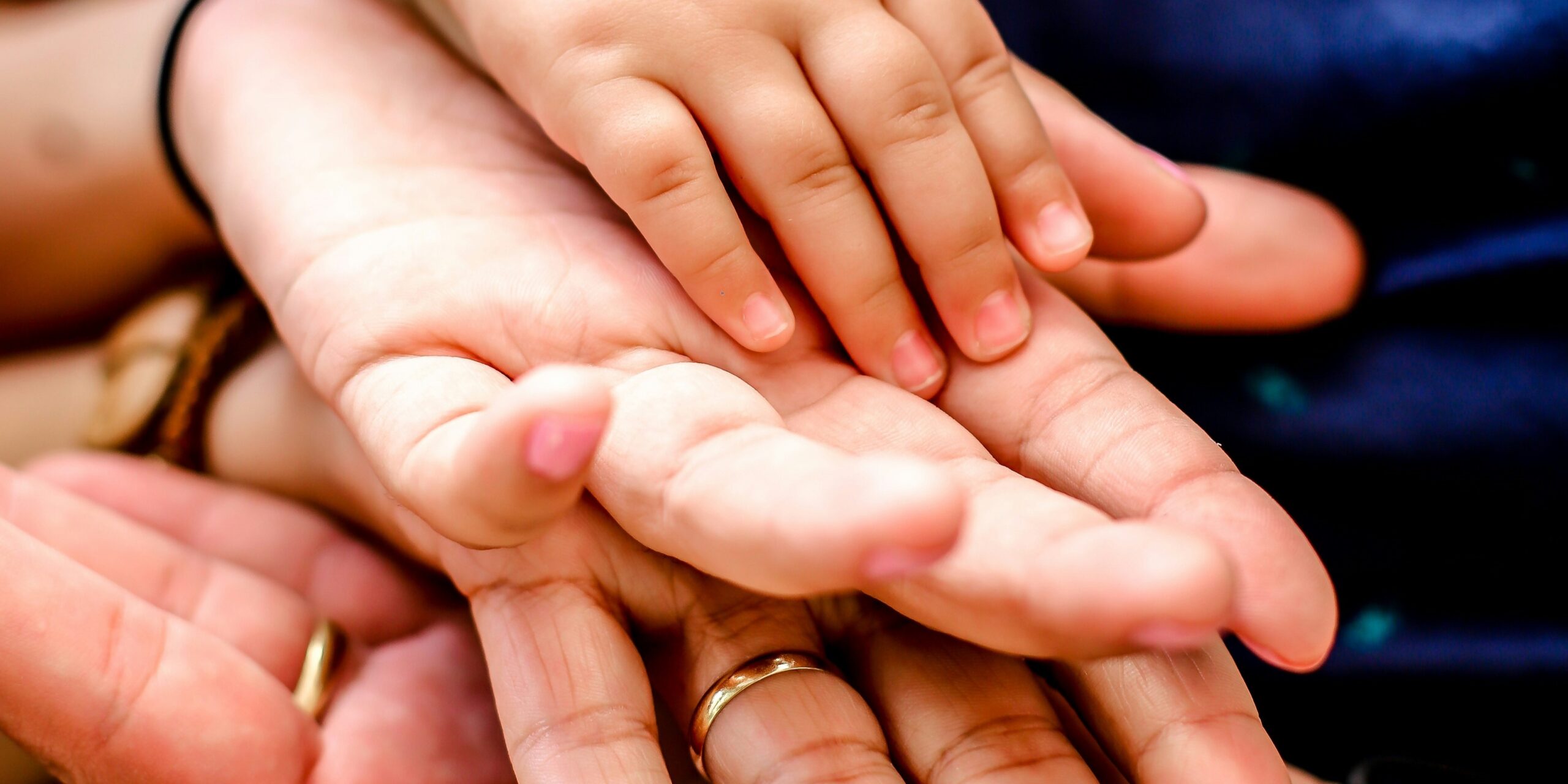 People holding hands, a man, a woman, a toddler